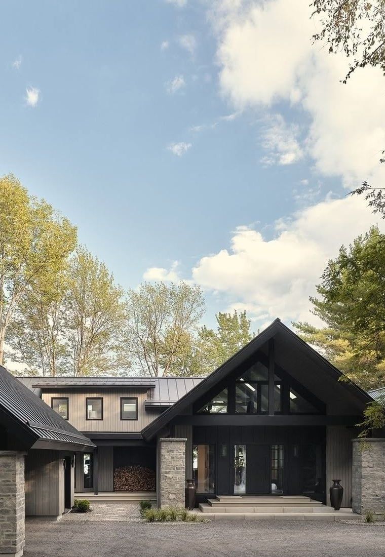 Stone piers, a dark gable, and a gravel court under oaks.